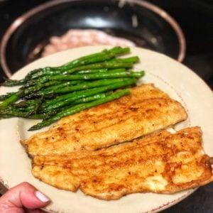 a plate of pan fried trout and asparagus