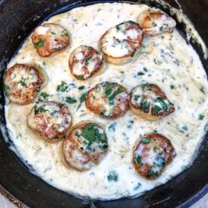 a cast iron pan of creamy garlic scallops