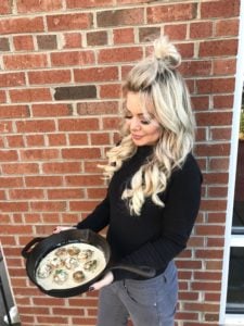 me holding a cast iron skillet of creamy garlic scallops