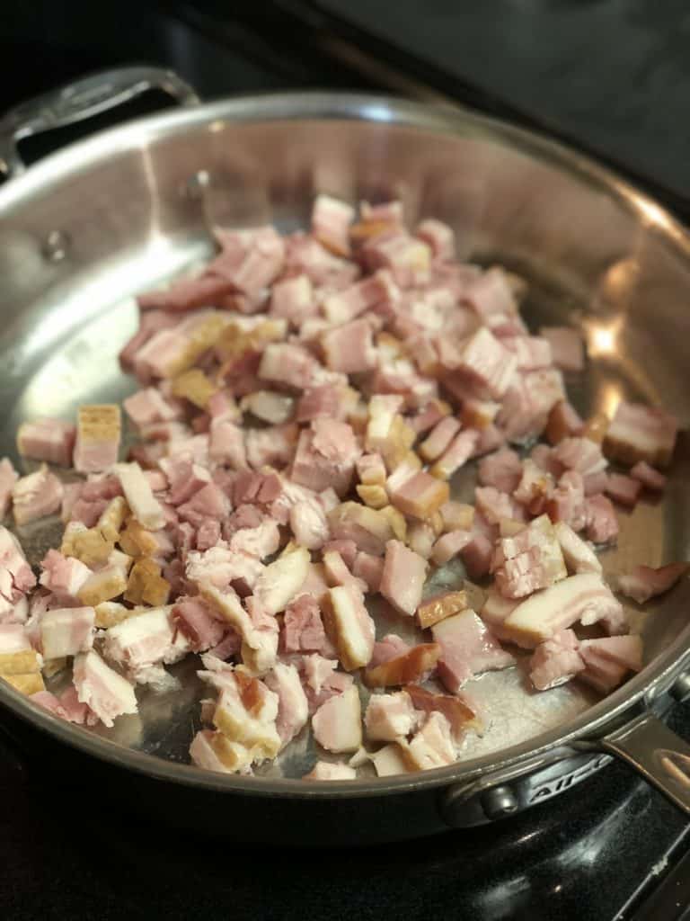 chopped bacon frying in a pan for pasta carbonara