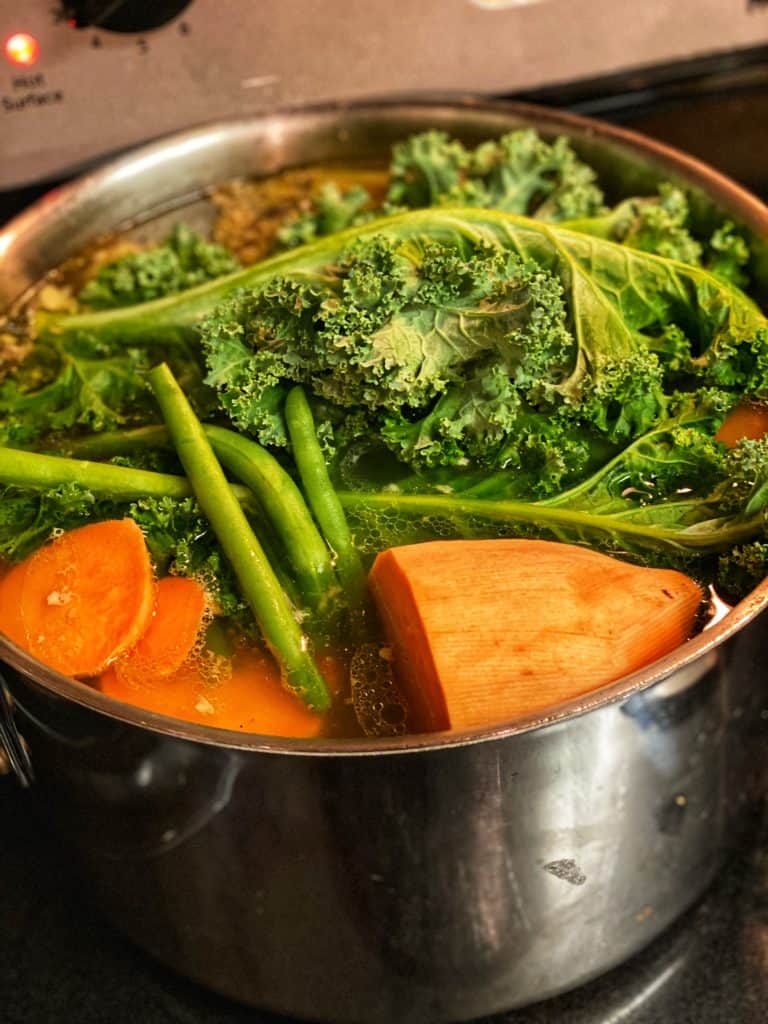 chicken bones and vegetables in a stock pot