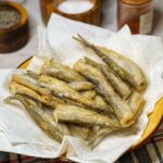 Crispy Fried Smelt Fish sitting in a paper towel lined bowl.
