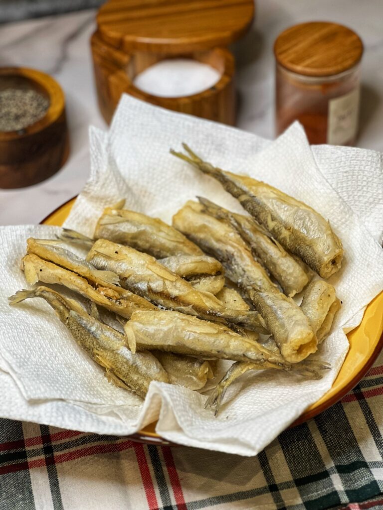 Crispy Fried Smelt Fish sitting in a paper towel lined bowl.