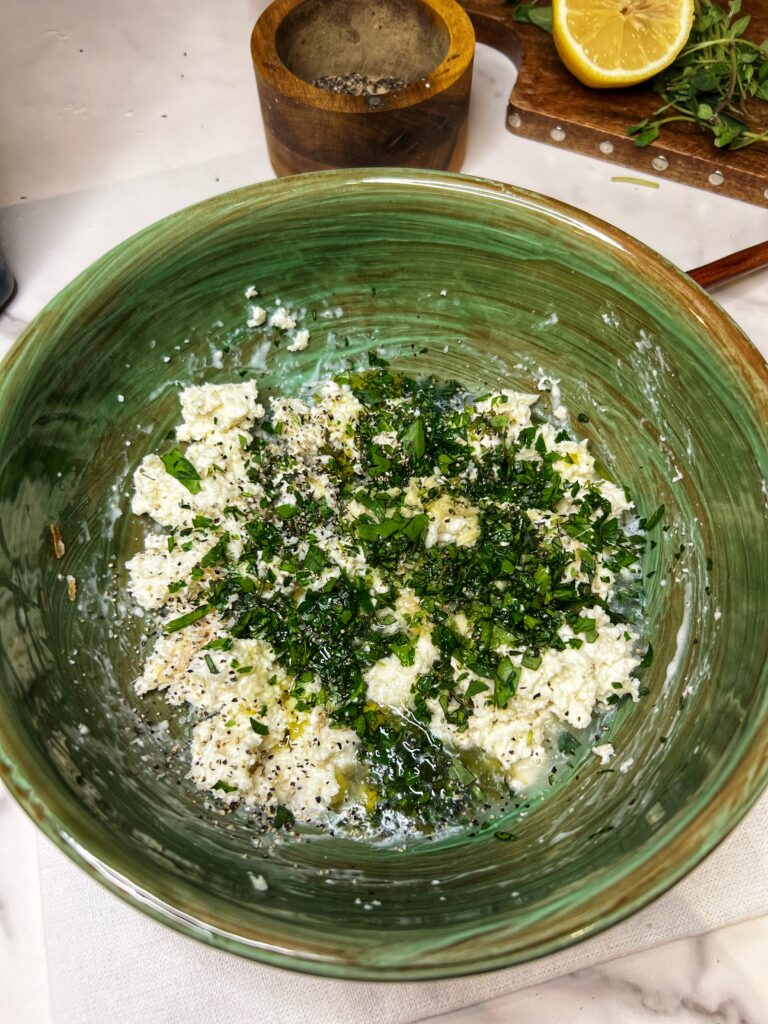 Ingredients for Clams Oreganata unmixed in a green bowl.