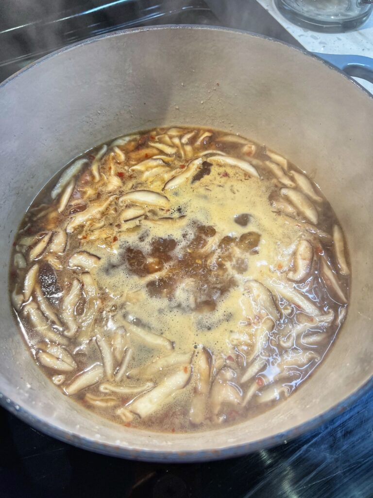 Hot and sour soup simmering in a pot.