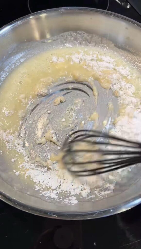Whisking flour and butter in a pan.