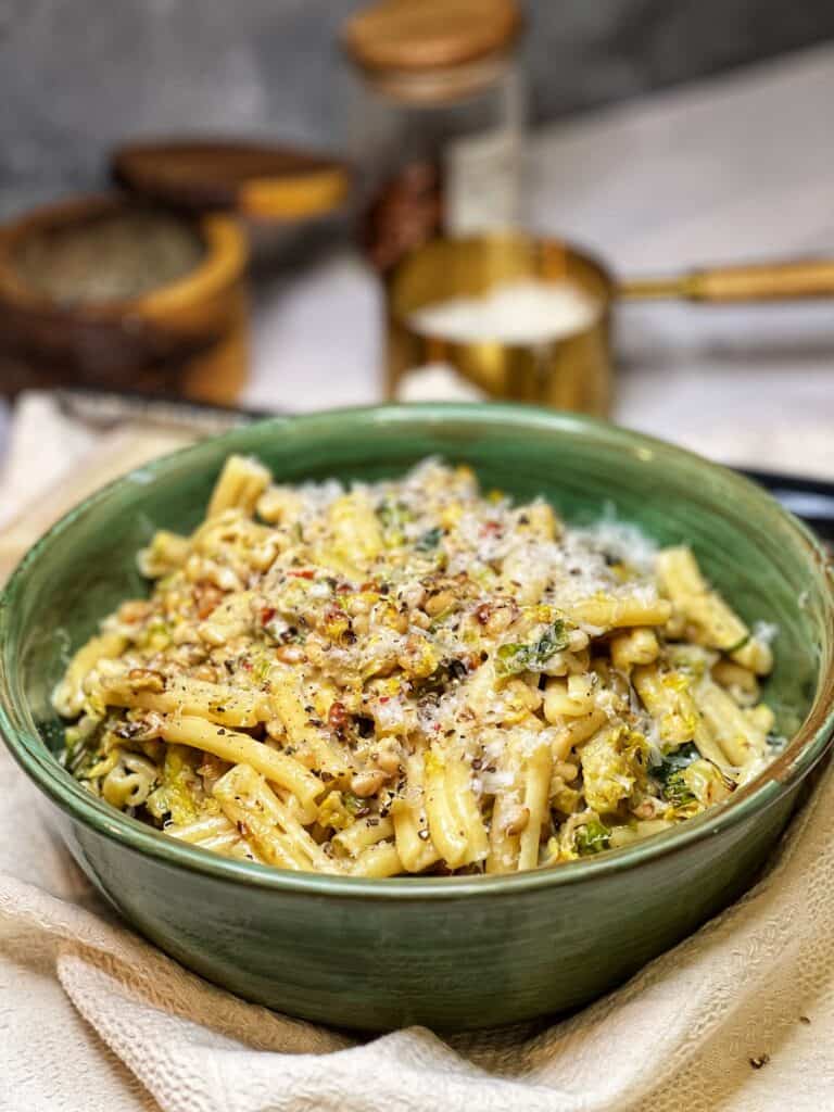 A medium-sized green bowl filled with Roasted Brussels Sprouts Pasta.