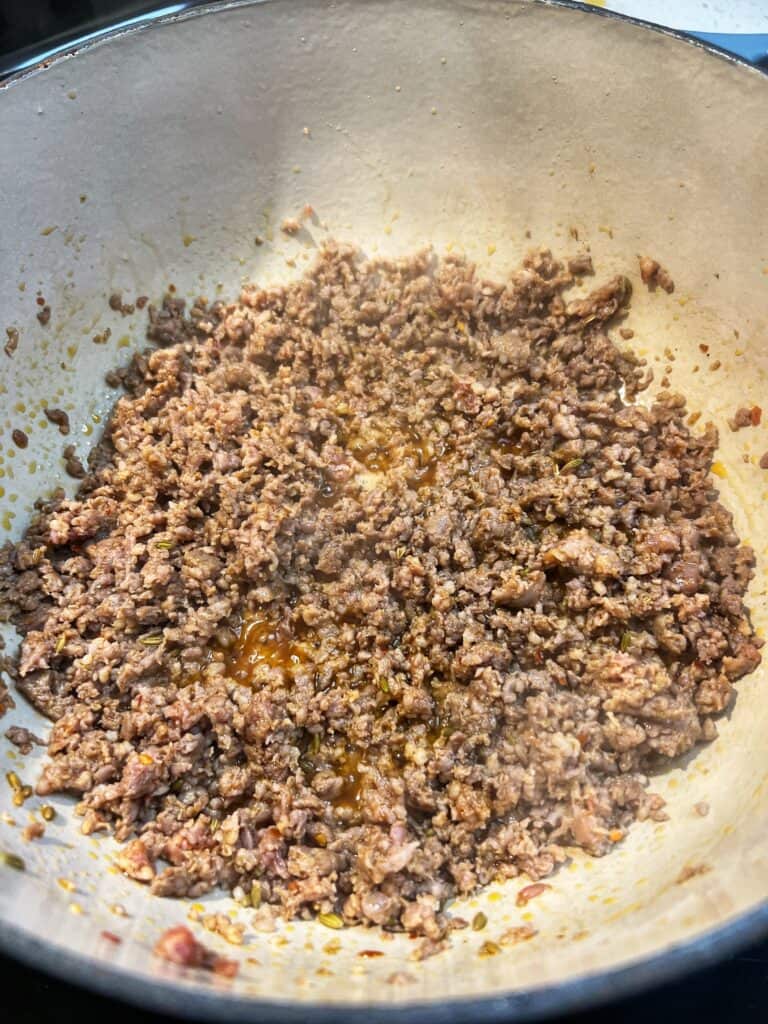 Ground hot sausage that has been browned in a pot.