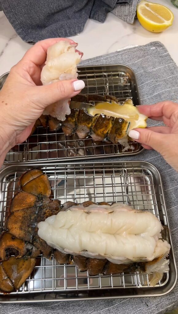 Placing a lemon wedge in between a lobster tail shell and the meat on top.