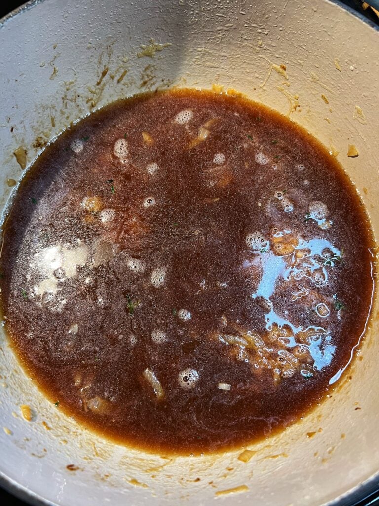 A pot of beef stock base and caramelized onions simmering for French Onion soup.