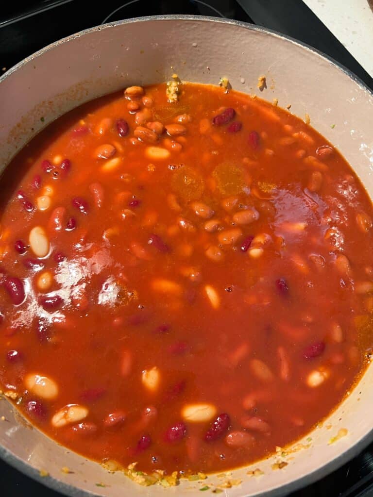 V-8 juice in a pot with ground turkey and beans for chili.