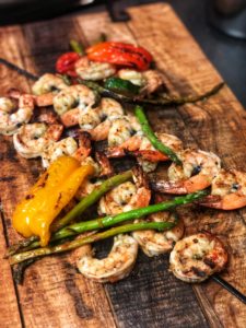 grilled shrimp and vegetables on a wooden platter for my orzo with pesto grilled shrimp