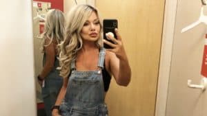 me taking a selfie in the target dressing room wearing overalls