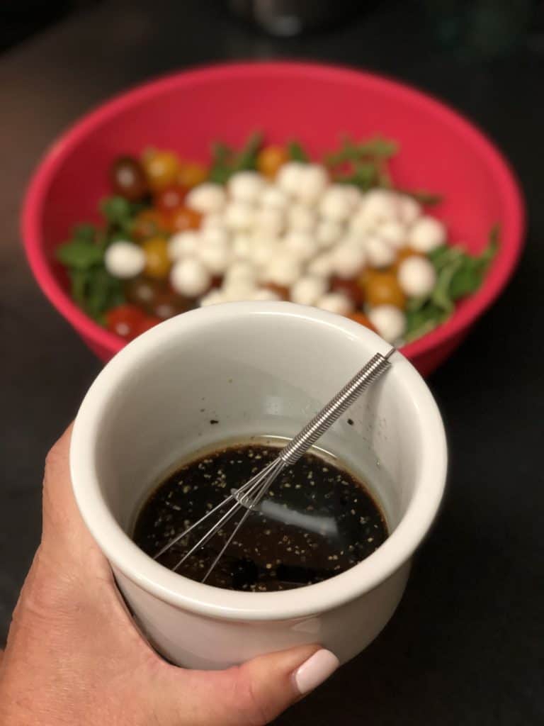a small bowl of dressing for arugula salad for veal milanese