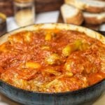 A blue enameled cast iron pan filled with cooked cabbage rolls (halupki).