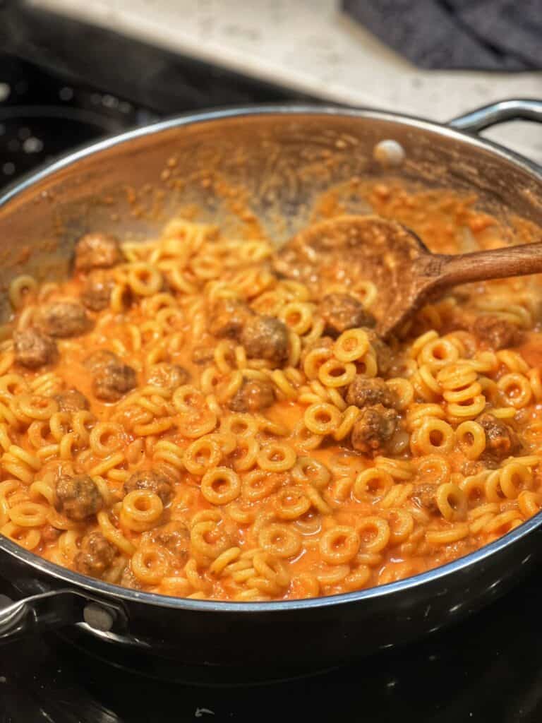 A pan of Spaghetti O's with mini meatballs. The sauce is tomato cream based.
