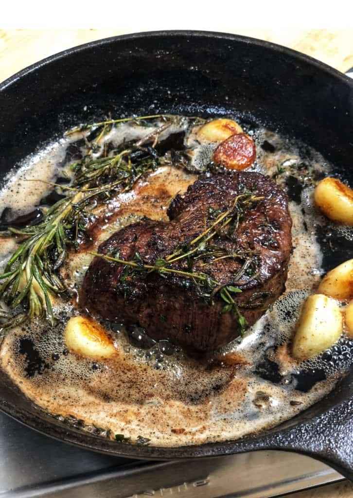 a filet searing in a cast iron pan