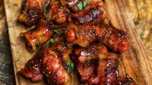 a wooden platter of bacon wrapped smokies