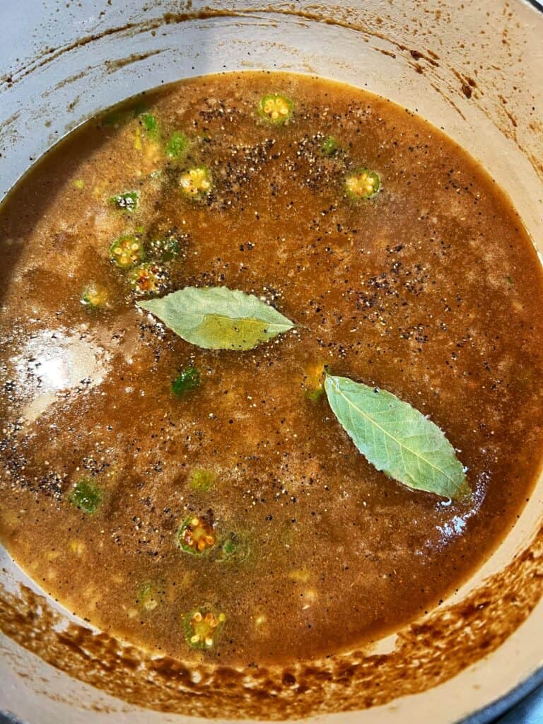 Two bay leaves added to the base for New Orleans Style Gumbo. The soup is brownish in color.