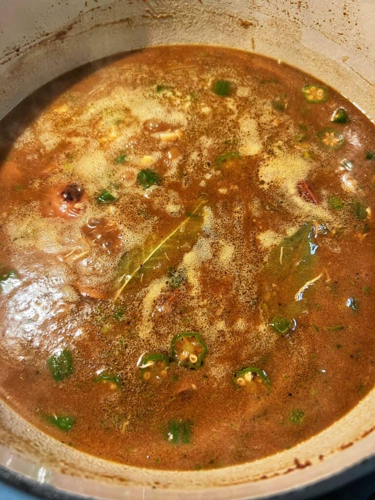 Simmering gumbo in a pot. The gumbo is dark brown in color.