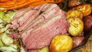 a cast iron pan of corned beef, cabbage, carrots, and potatoes