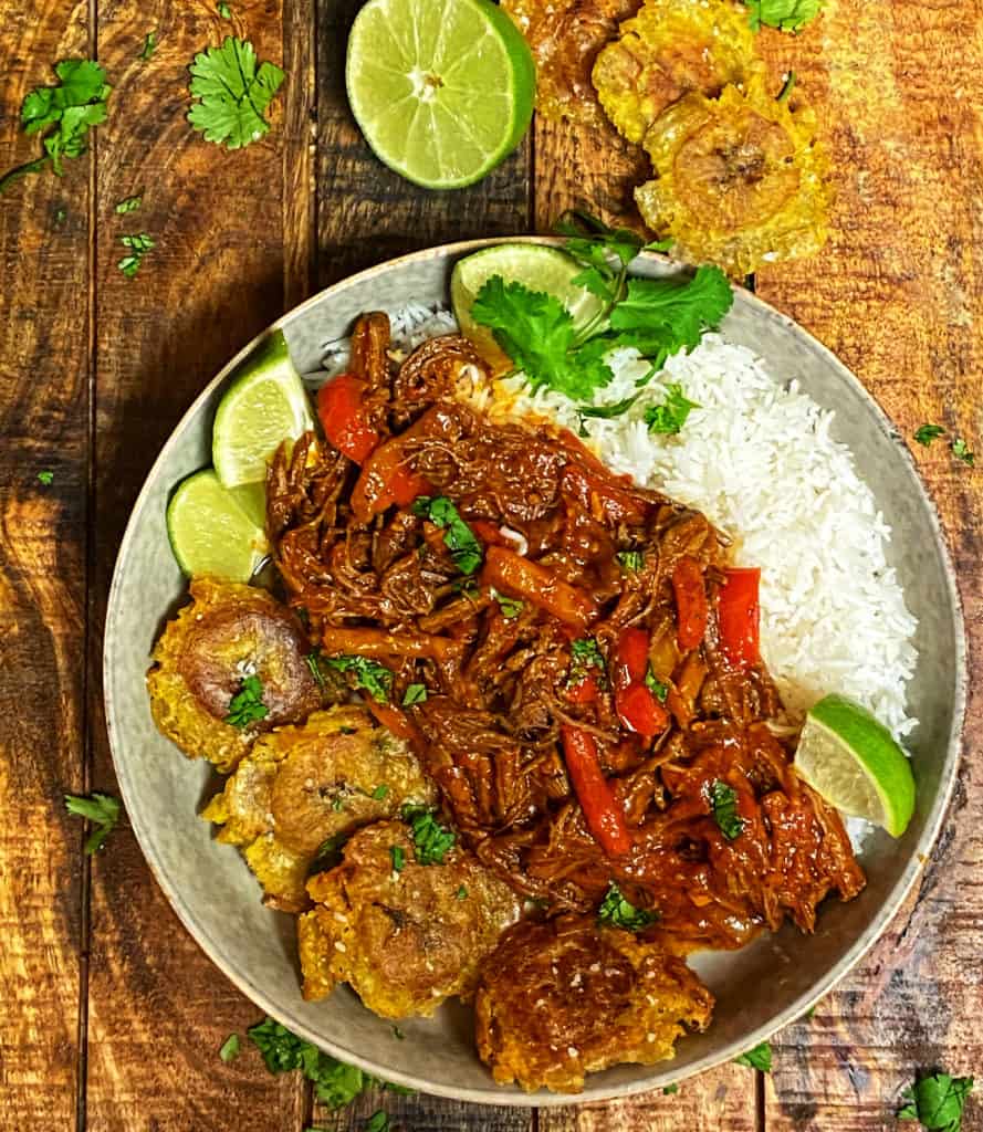 a bowl of rice with ropa vieja and tostones