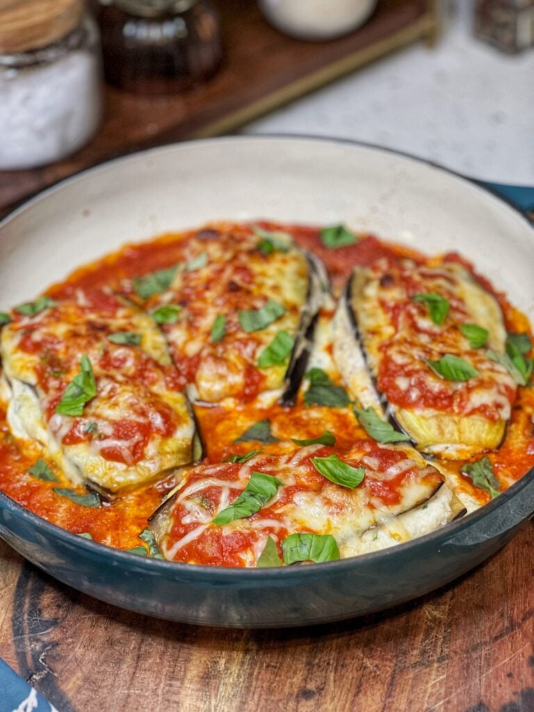 A pan of low carb eggplant Parmesan. The eggplant is sliced and sautéed and stacked with layers of ricotta cheese and marinara sauce.