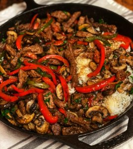 pepper steak and rice in a cast iron pan
