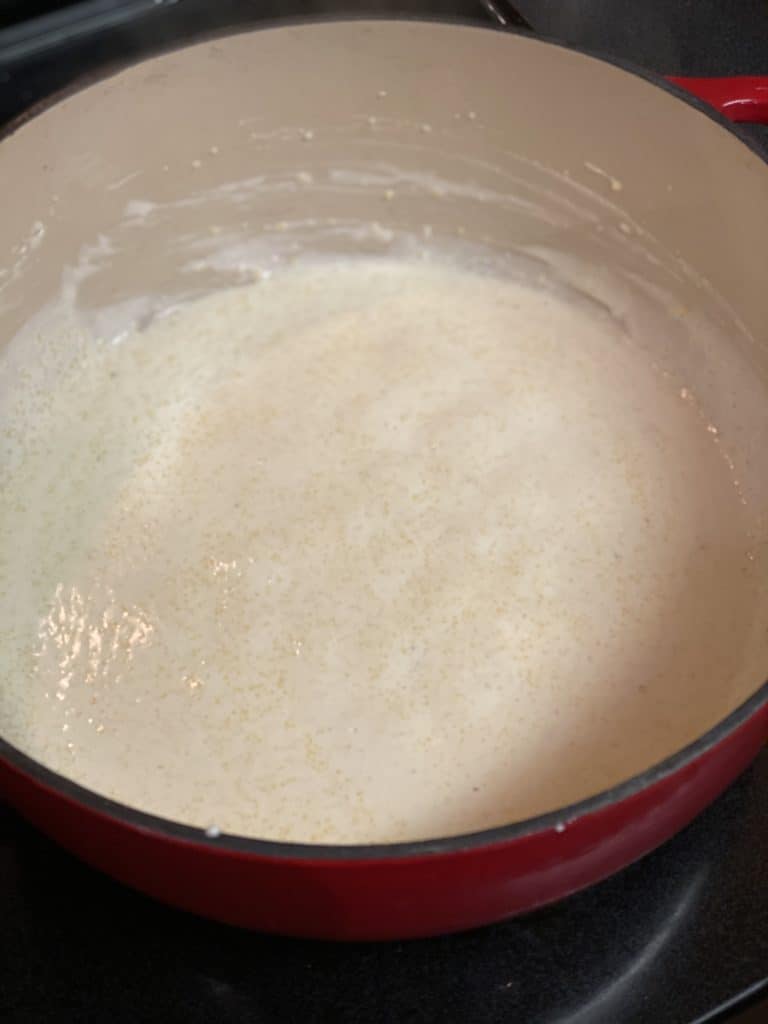 half and half in a pot for creamy polenta with mushrooms