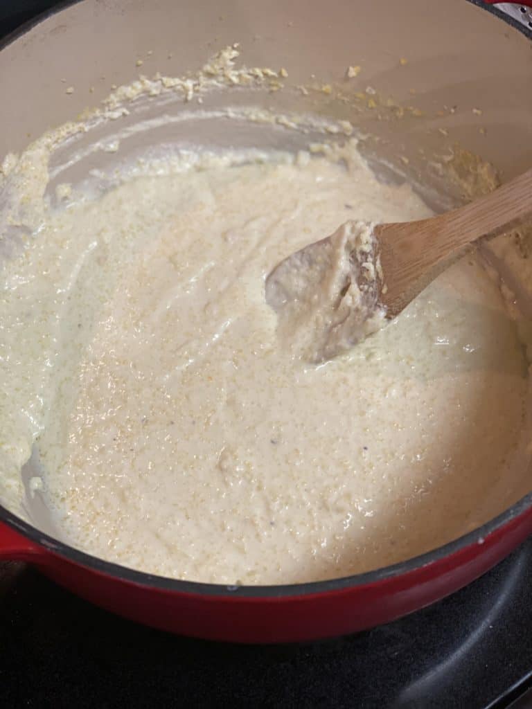 stirring creamy polenta with a wooden spoon