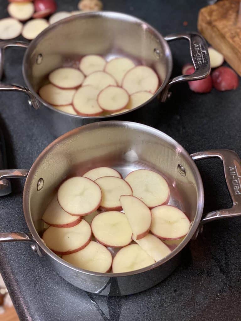 a layer of sliced red potatoes in a small baking pot