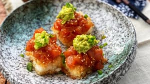 three crispy rice squares topped with sushi grade tuna and smashed avocado