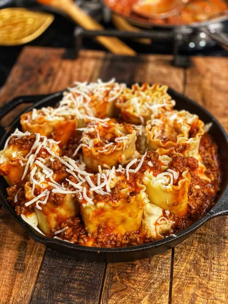 a cast iron pan full of lasagna rollups