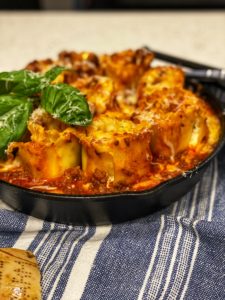 a cast iron pan full of lasagna rollups