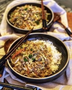 two bowls of egg roll in a bowl with rice and chopsticks