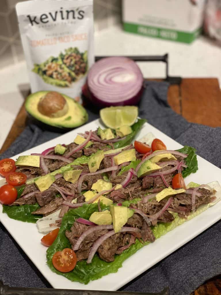 four Tomatillo Taco Shredded Beef lettuce tacos on a white plate