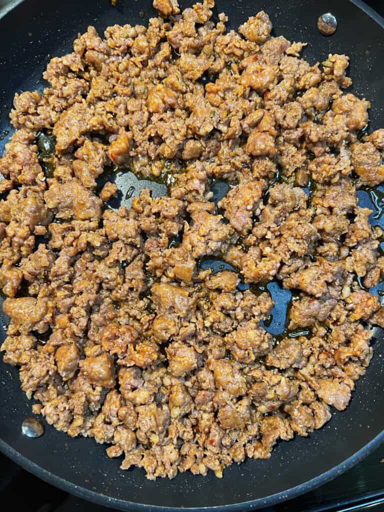Browned, broken up hot sausage in a non-stick pan.