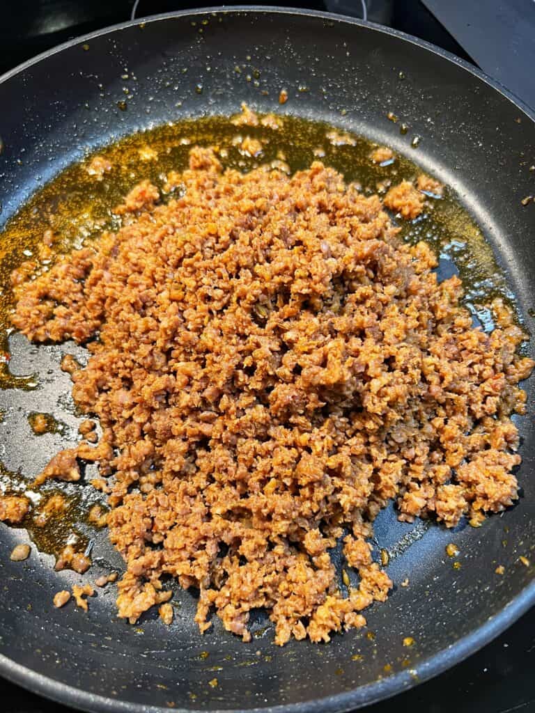 Ground and browned hot sausage in a non-stick pan.