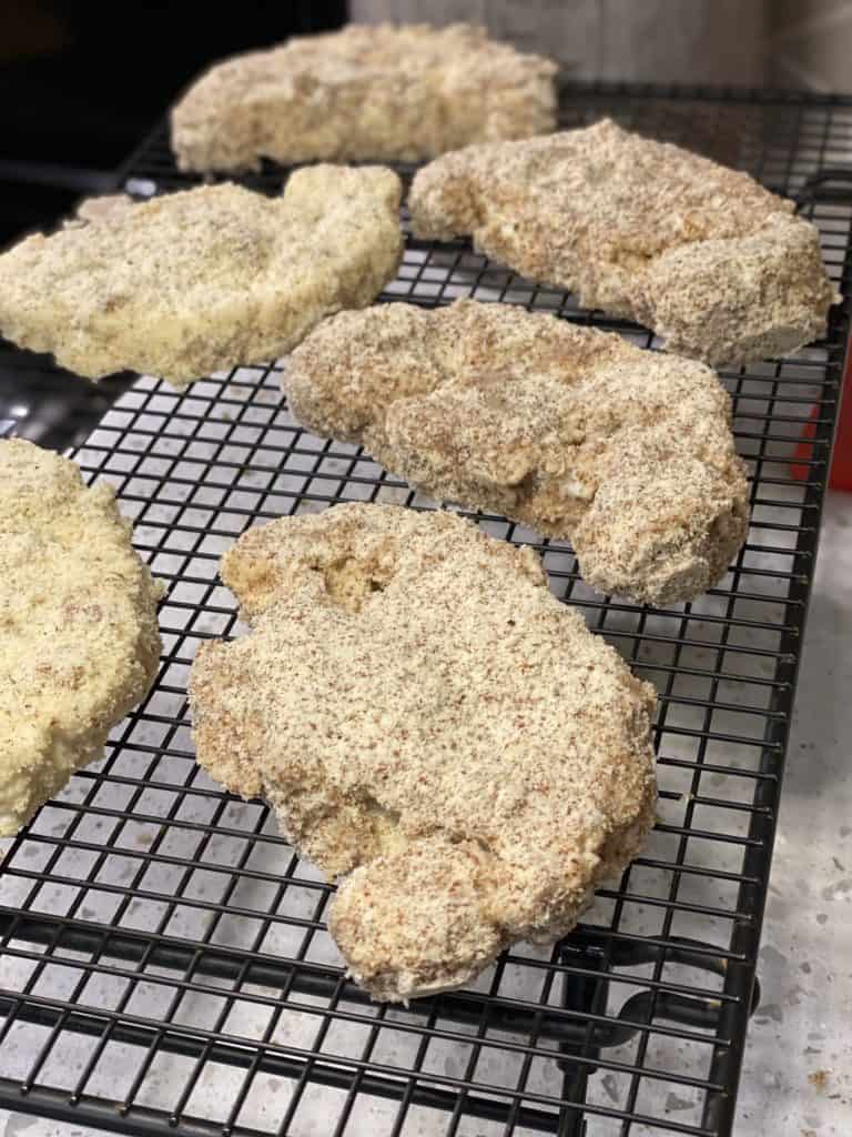 coating cauliflower steaks drying on a baking rack
