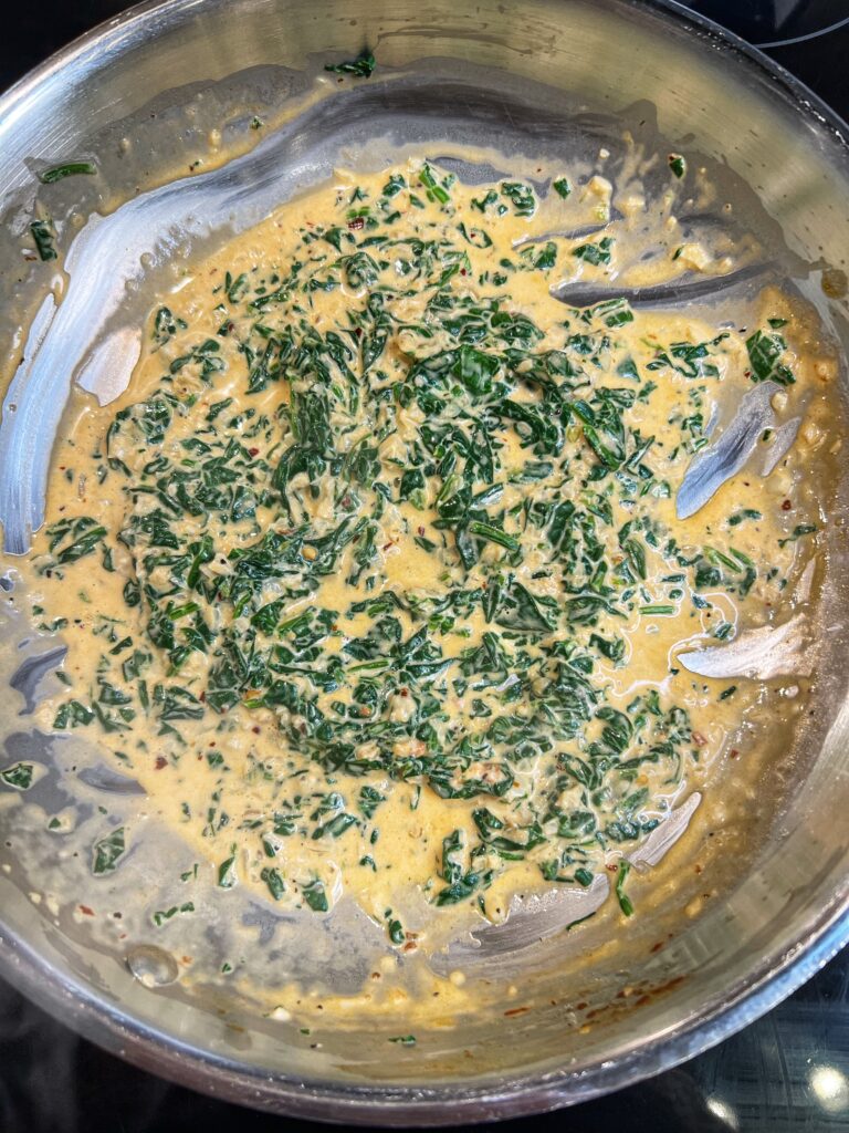 Tomato cream sauce with spinach in a pan.