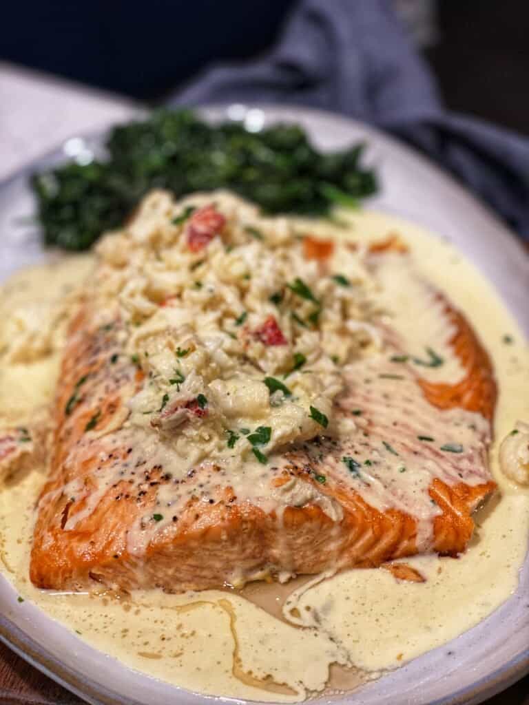 a platter with roasted salmon topped with lobster newburg sauce