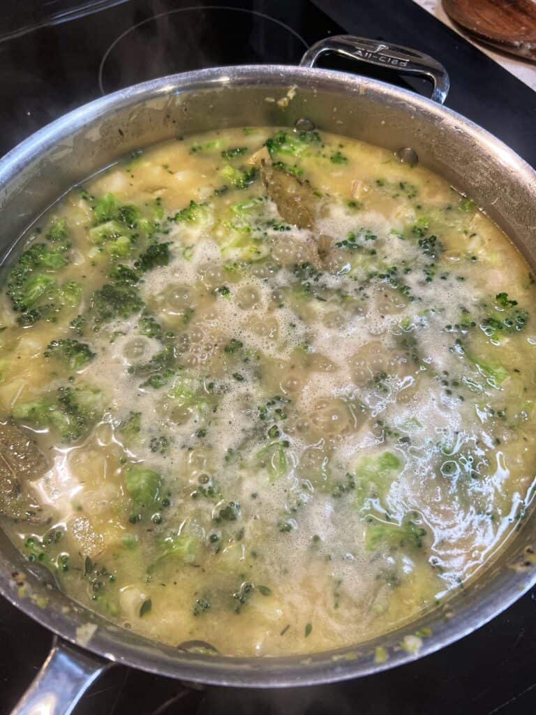 Broccoli and potatoes simmering in chicken stock.