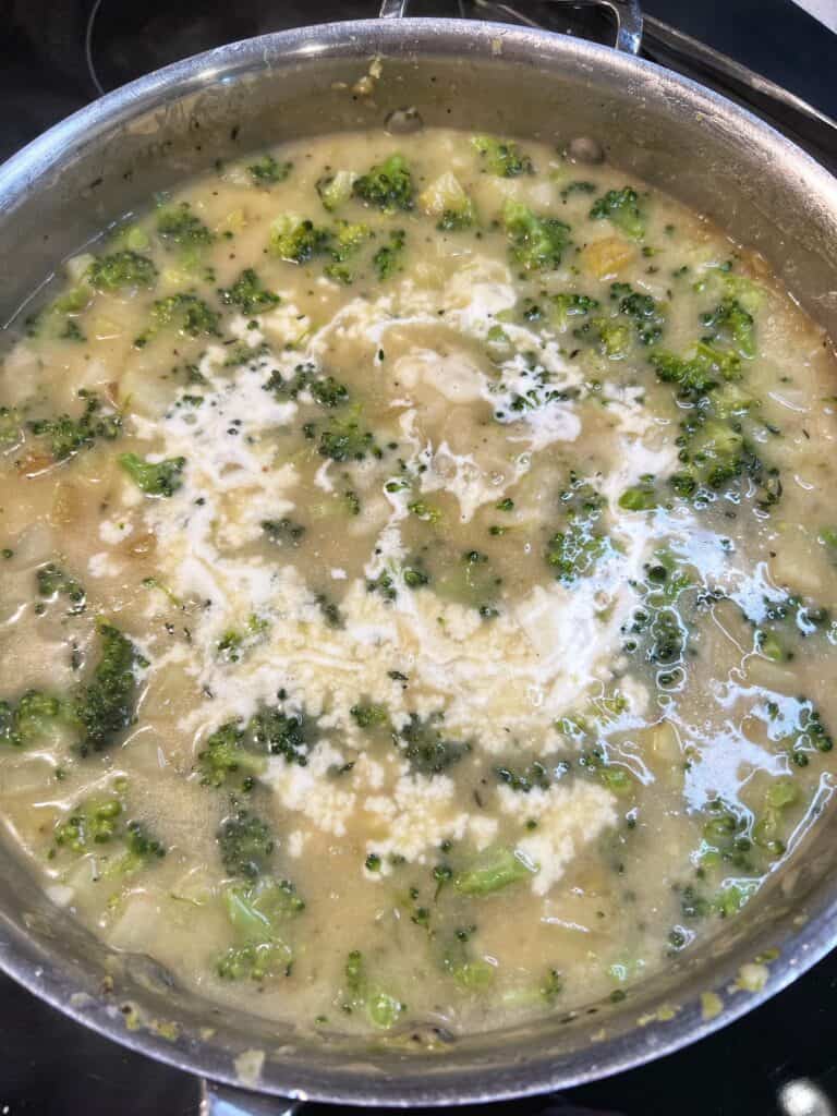 Heavy cream added to a pan with a base for Broccoli Chicken Pot Pie.