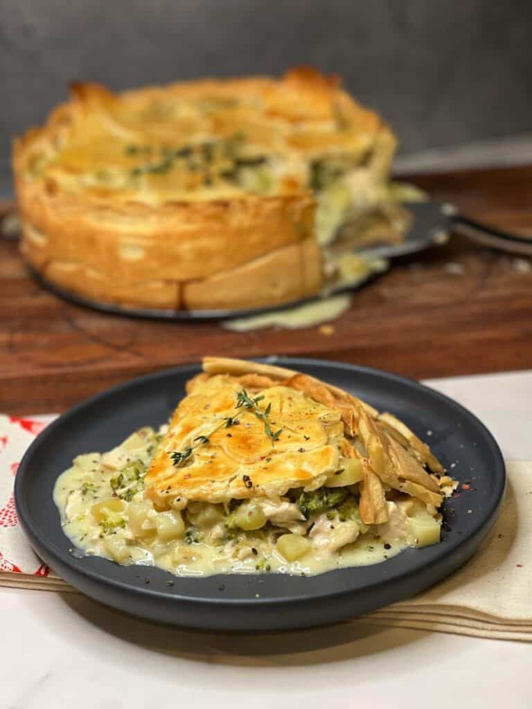 A piece of broccoli chicken pot pie on a charcoal colored plate.