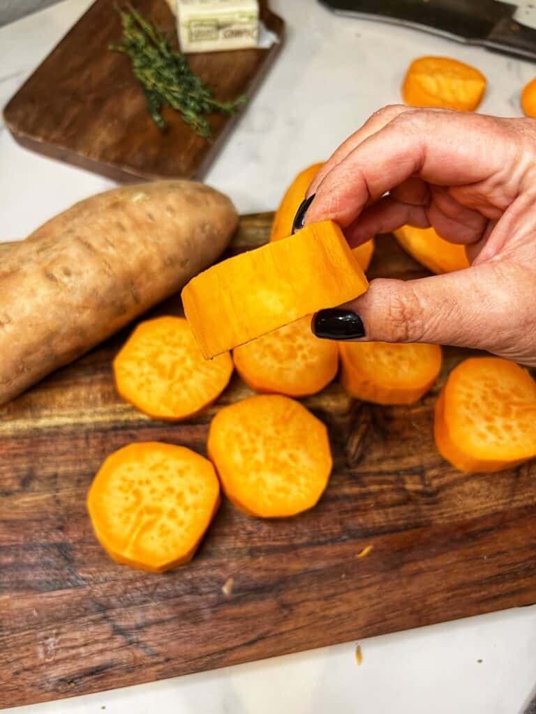 Me holding a round cut piece of sweet potato.