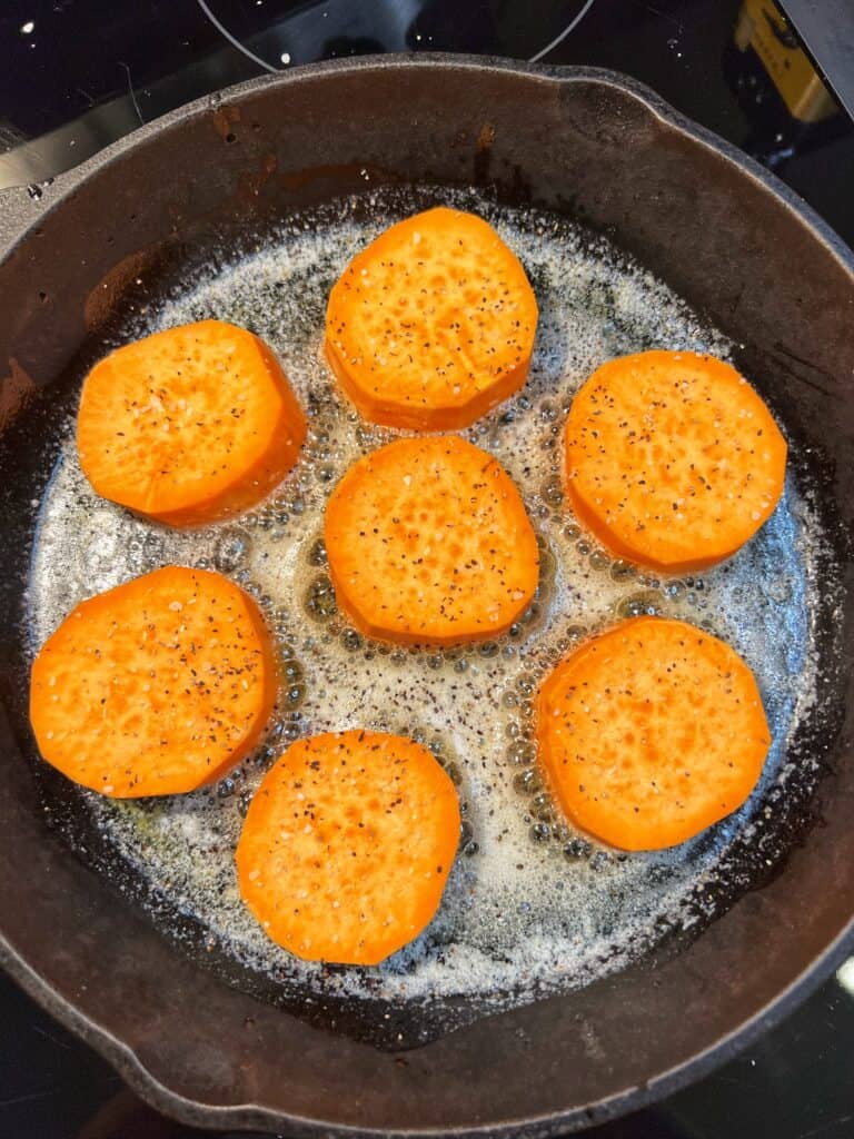 Round pieces of sweet potatoes in a cast iron pan with butter.