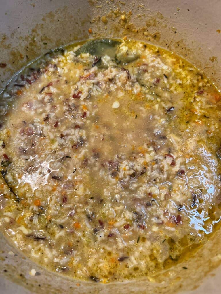 Creamy chicken wild rice soup base simmered in a pot.