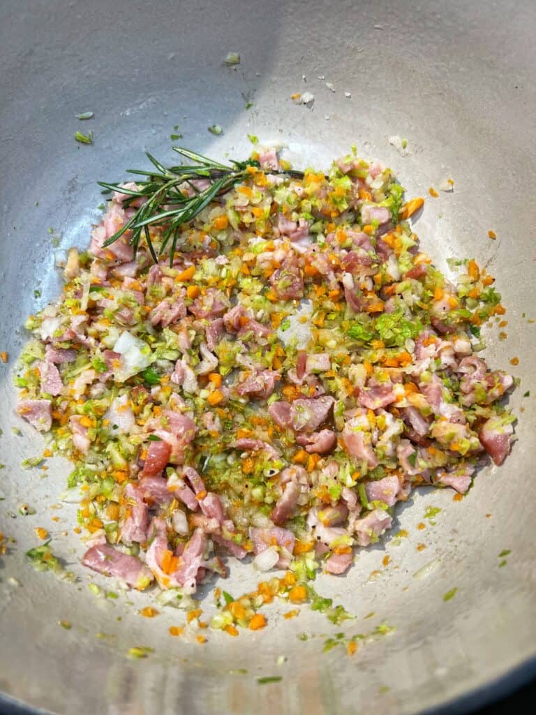 Vegetables and bacon softened in a pot for One Pot Pasta Fagioli