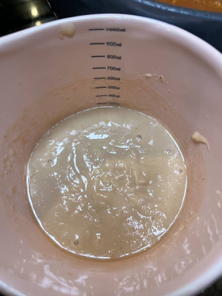 A can of blended cannelini bean in a pink bowl.