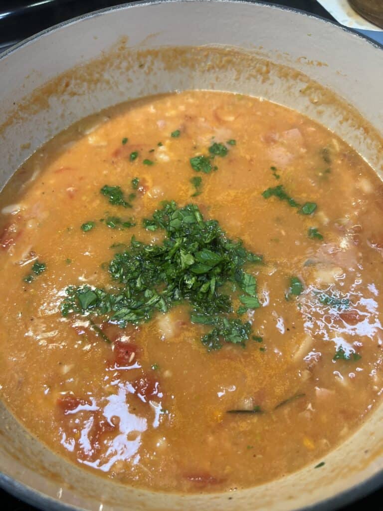 Pasta Fagioli in a soup pot garnished with fresh parsley